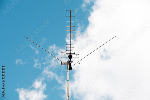 A large antenna stands out against a blue sky with fluffy clouds