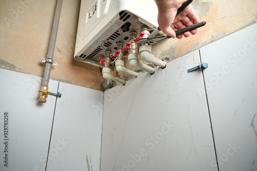 Double-circuit gas boiler on the wall. Plumbing connections and pipes of the domestic heating system. Regulation pipe from water heater. Valve.