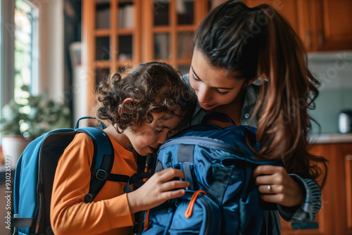 A mother helping her child pack a backpack for the first day of school. spring, motherood moments, preparing for school