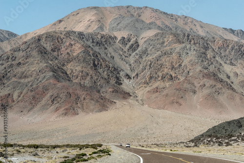 Inmensa montaña al lado de la ruta con autos.