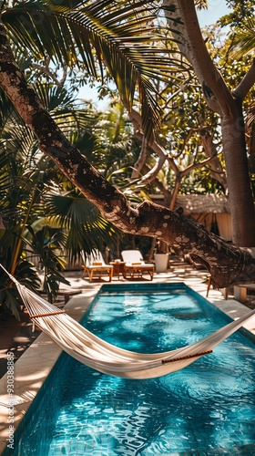 Hammock hanging between trees near the swimming pool, nobody. Summer vacation holiday travel resort relaxation outdoors, luxury poolside hotel deck, tropical villa garden backyard 