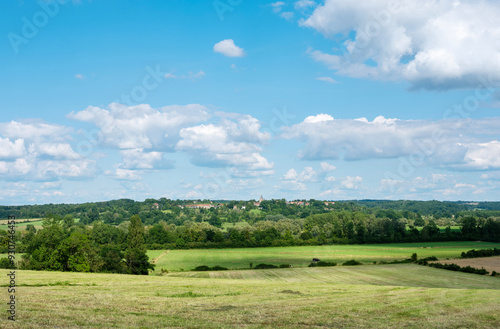 countryside landscape of pays d'argonne with village and trees under blue summer sky