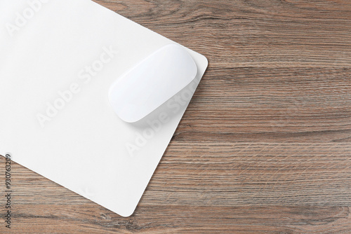 Computer mouse with mousepad on wooden desk, top view. Space for text