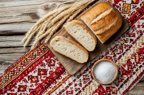 Bread and wheat on a traditional Eastern European tablecloth with a red pattern