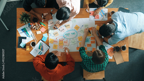 Group of business people writing and making mind map to brainstorming marketing idea at meeting. Top aerial view of investors sharing plan or strategy by using sticky notes. Top view. Convocation.