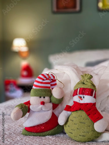 Bonecos de Papai Noel e Boneco de Neve sobre Cama em Ambiente Aconchegante