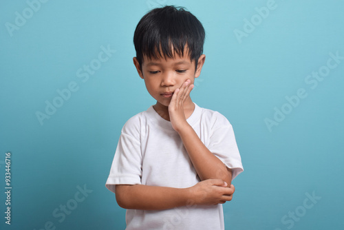 Little Asian boy suffering from toothache. toothache emotions large inflated cheek. A sad child with a toothache. Dental problem.