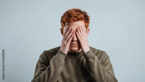 A person is covering their eyes with their hands