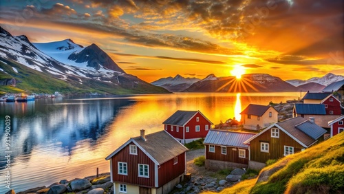 Vibrant midnight sun casts a golden glow on Hammerfest's rustic wooden houses, snow-capped mountains, and tranquil Norwegian fjords during the eternal summer solstice.