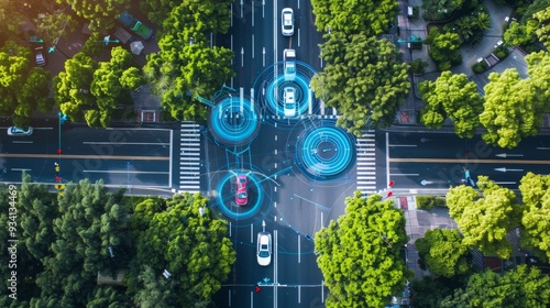 Aerial view of autonomous cars navigating a city intersection, highlighted by digital overlays illustrating advanced driving technology and connectivity