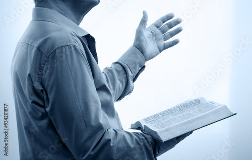 A man with a bible preaches