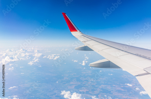 View from the airplane window at a beautiful cloudy sky and the airplane wing