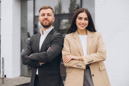 Portrait of a team and partners of a young business man and woman standing outside the office center with crossed arms, smiling and confidently looking at the camera.