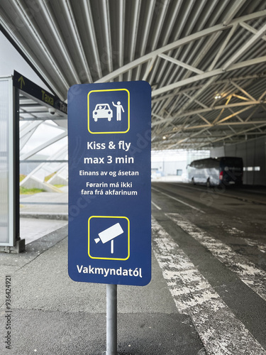 “Kiss and Fly” sign at airport drop off area in Vàgar, Faroe Islands. Sign indicates time restriction for kissing to three minutes. Vakmyndatòl translates to surveillance cameras.