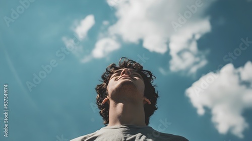 A photograph of a person feeling hopeful and inspired gazing up at the vast open sky with a slight smile conveying a sense of promise potential and possibility for the future