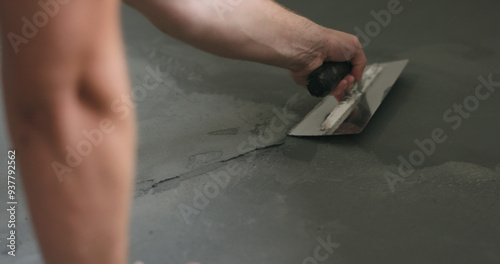 closeup worker applying micro concrete on the floor with a trowel