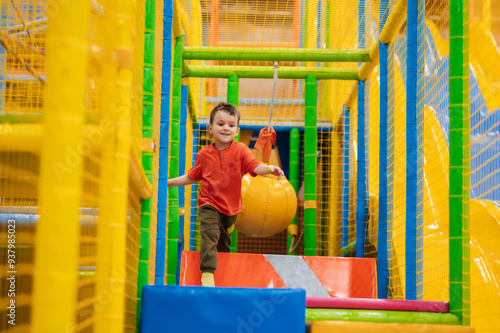 Cute baby boy playing on the playground at the children's play center