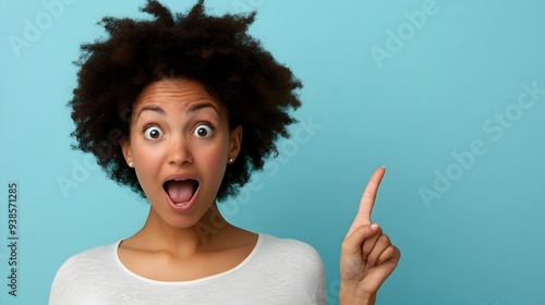 Portrait of a surprised and amazed man pointing to the side with a shocked astounded expression on an isolated studio background The person is showing a powerful emotional reaction and gesture