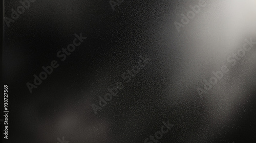 Black matte textured background with floating dust particles illuminated by soft light in the top right corner, creating a deep contrast between black and white. This abstract design emphasizes textur