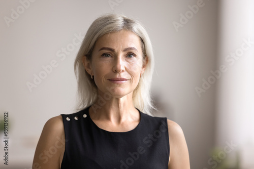 Middle-aged businesswoman look at camera with serious face expression, standing, pose at home office, head shot close up portrait. Midlife, natural beauty, profession occupation person profile picture