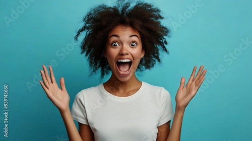 Curly optimistic woman raises palms from joy happy to receive awesome present from someone shouts loudly dressed in casual white t shirt isolated on blue background Excited Afro female : Generative AI