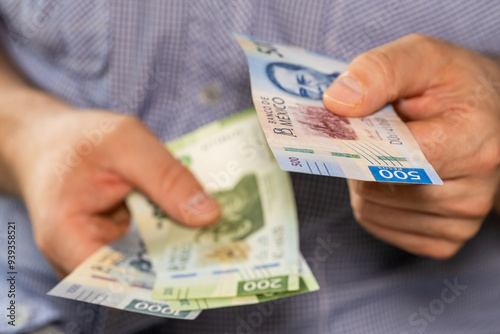 Mexico money. Man giving someone a 500 peso bill, Business concept