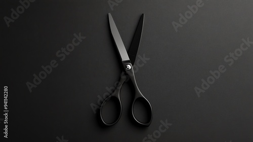 A pair of black scissors on a black background.