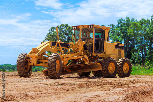 Having to work at construction site with heavy earthmoving construction grader tractor