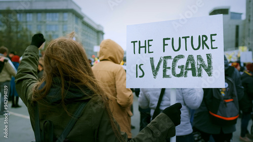 Vegetarian person hold veganism protest banner. Animal rights demonstration placard. Activist stand city street. Go vegan eco picket. Don't eat meat diet. Stop cruelty march. Save planet strike crowd.