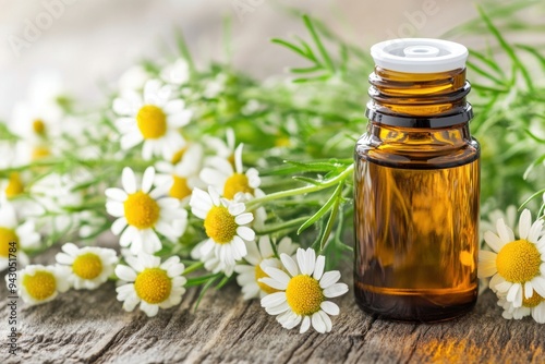 Calming chamomile essential oil with fresh flowers on wooden surface