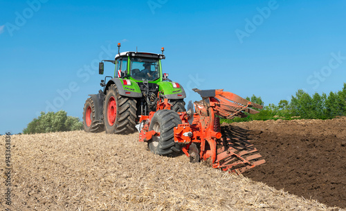 Tractor with 7-share reversible plow cultivating the field after the grain harvest - 2184