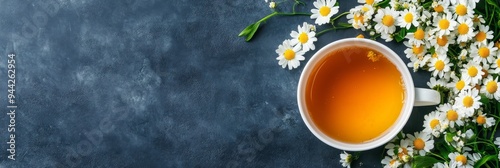 A cup of steaming chamomile tea sits on a rustic background, surrounded by fresh chamomile flowers. The image evokes a sense of tranquility, relaxation, and the natural healing properties of chamomile