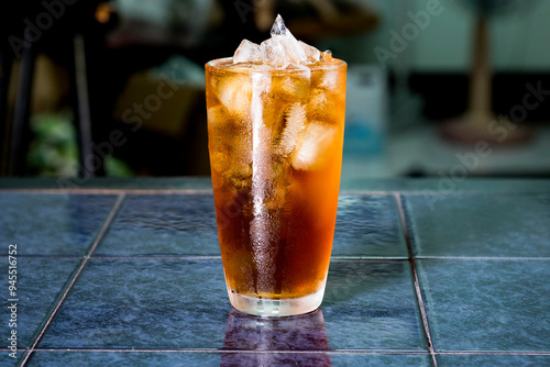 Americano ice coffee in a glass, isolated on table, selective focus blur background