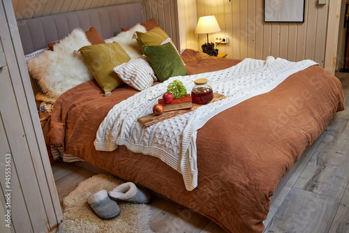 Modern bedroom interior, double bed with beige linen bedspread and colorful pillows