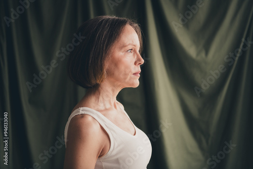 Unretouched photo of attractive old lady look profile side empty space isolated green color linen background