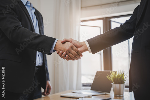 close-up view hands of agent and client shaking hands after signed contract buy new apartment.