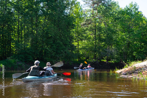 Group kayak trip for seigneur and senora . An elderly couple And adult rowing boat on the river, a water hike, a summer adventure. Age-related sports, mental youth and health, tourism, active old age