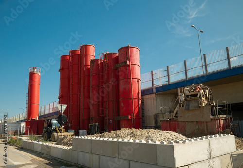 silosy na cement na środku placu budowy w letni słoneczny dzień