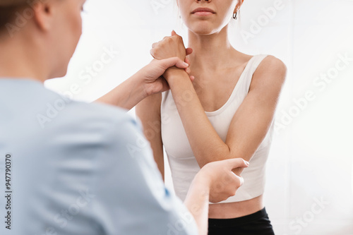 posture correction. Chiropractic, back pain relief. Professional female physical therapist doing shoulder, elbow and hand massage in hospital elbow