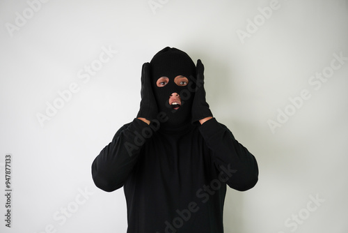 Shocked Young Adult black masked robber with gloves. Isolated over white background.