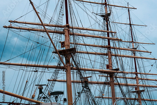 the mast of a ship with a boat