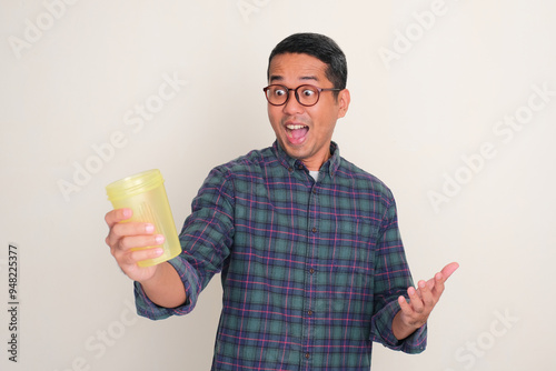 A man looking at drinking bottle that he hold with surprised expression