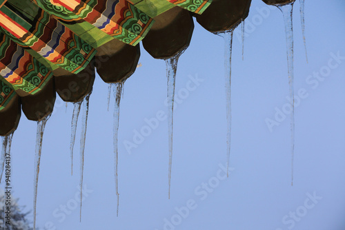 Low angle view of icicles on the eaves of tile roof house at Gyeongpodae Pavilion(Treasure No 2046) near Gangneung-si, South Korea