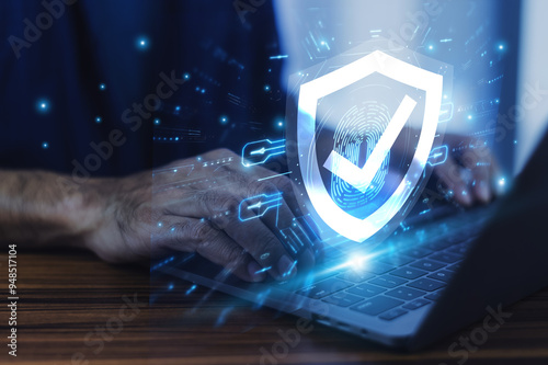 Man working on a laptop with advanced cyber security shield, ensuring the protection of sensitive data and securing the digital environment against potential threats.