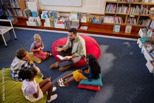 Friendly teacher reading a book to pupils during literature class