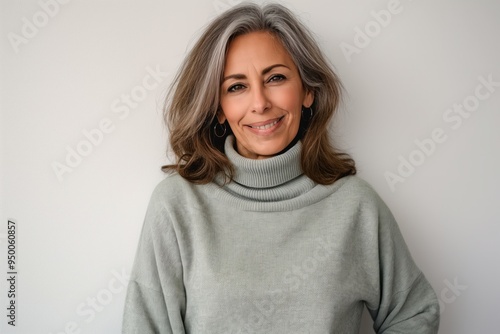 Middle-aged woman with happy, cool smile wearing casual turtleneck sweater on white background. Mature adult with attractive, confident facial expression and natural beauty.