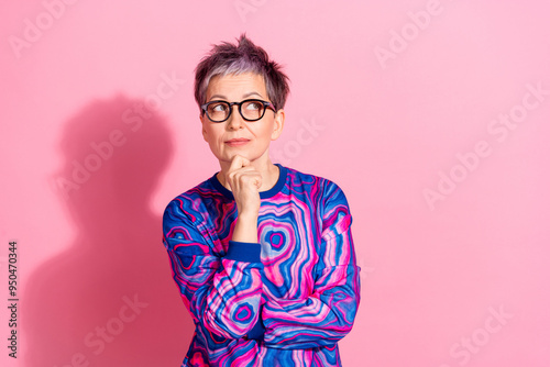 Photo portrait of attractive senior woman thoughtful look empty space dressed blue colorful clothes isolated on pink color background