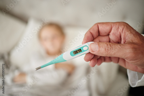 Parent, hand and reading thermometer for sick child in bed to monitor temperature for fever or covid infection. Person, kid and checking for cold, illness or flu in home for closeup or mpox symptoms