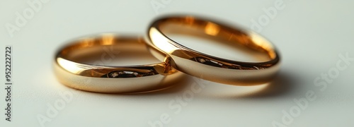 Two golden wedding rings rest together, glimmering softly, representing unity and eternal love shared between partners