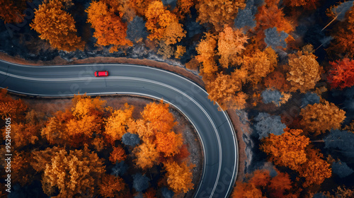 Aerial view of car traveling on a curvy road through autumn forest, fall foliage from above, scenic journey in nature, beautiful landscape with orange and yellow leaves, top drone shot